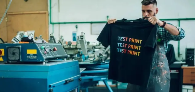 A man holding a Printed T-shirt.