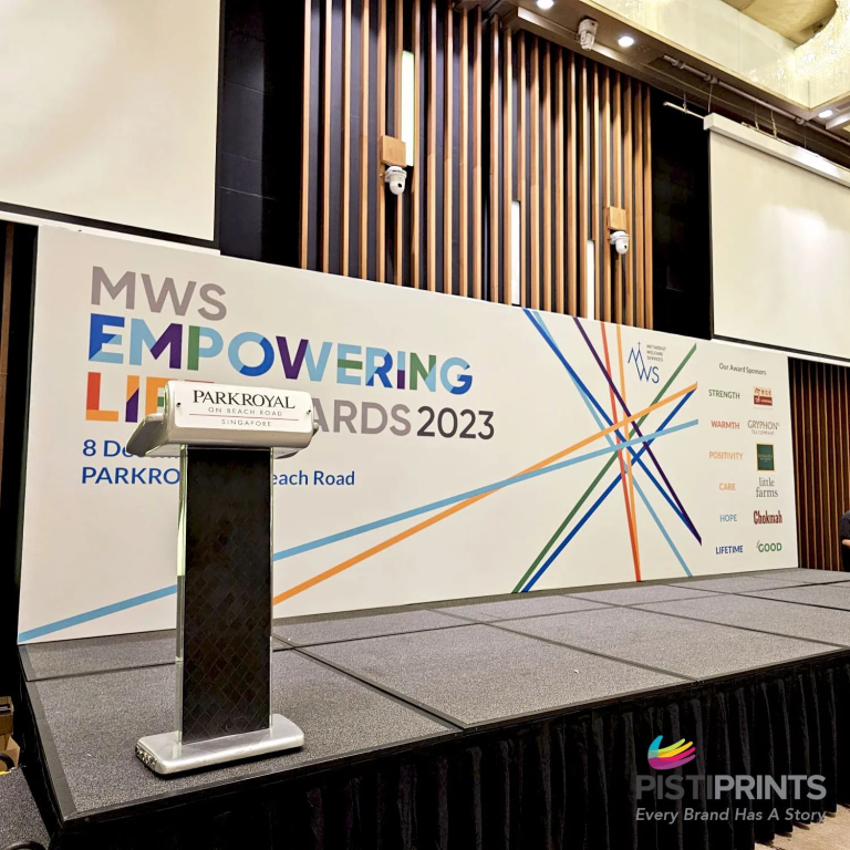 Premium event stage backdrop printed for the MWS Empowering Lives Awards 2023 at Parkroyal Singapore, showcasing high-quality event branding by PistiPrints.