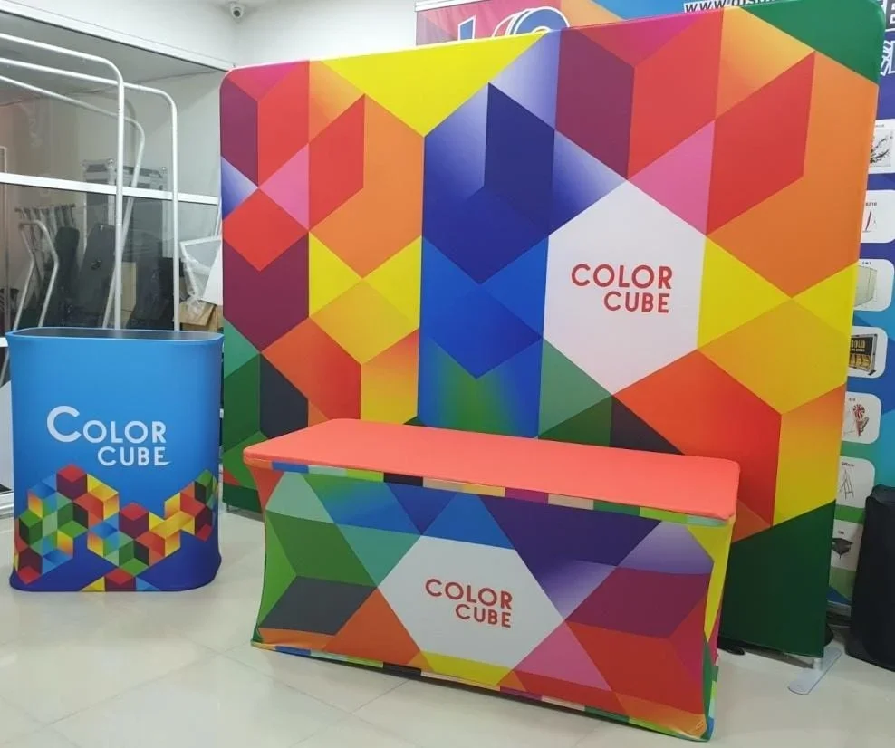 Vibrant custom stage backdrop and counters with geometric design and 'Color Cube' branding — demonstrating the visual impact of professional stage setups for events in Singapore.